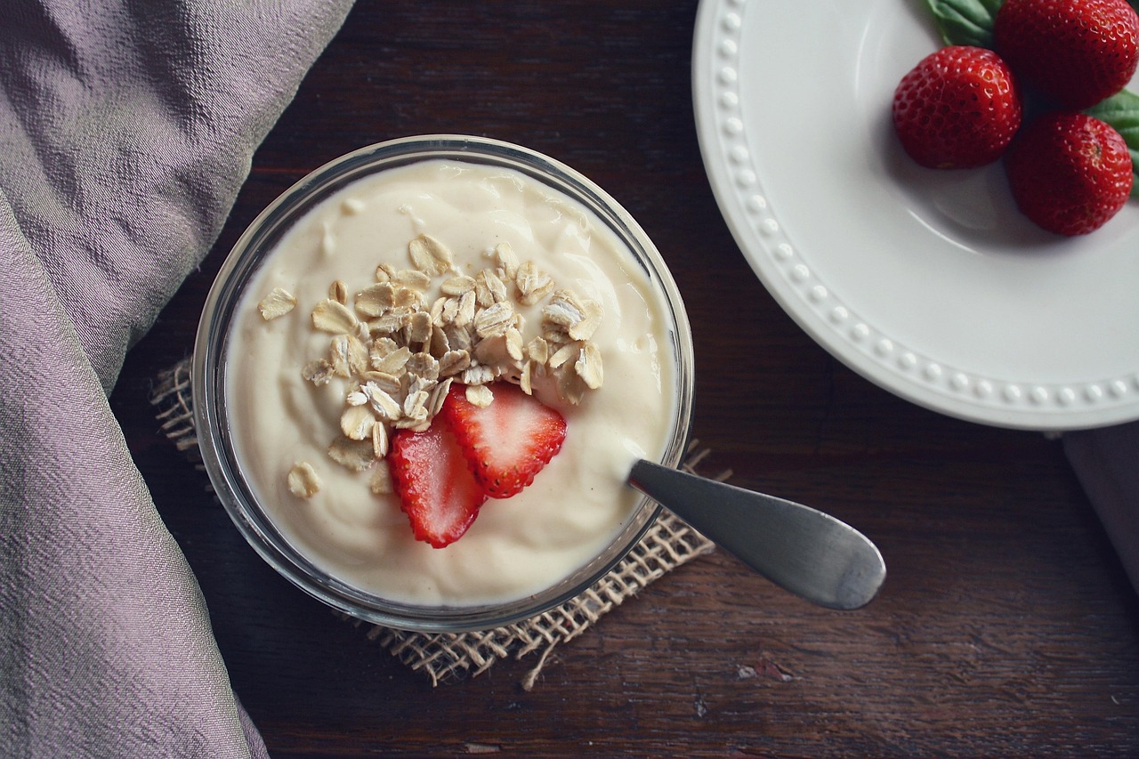 Immagine di un vasetto di yogurt con etichetta evidenziata, simbolo di avvertimento per la salute intestinale.