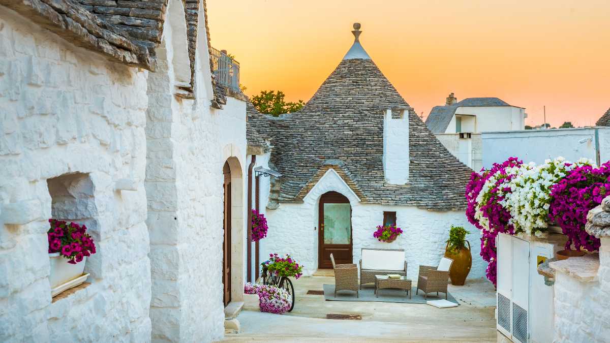 Trullo tradizionale pugliese immerso nella campagna italiana, simbolo di alloggi tipici.