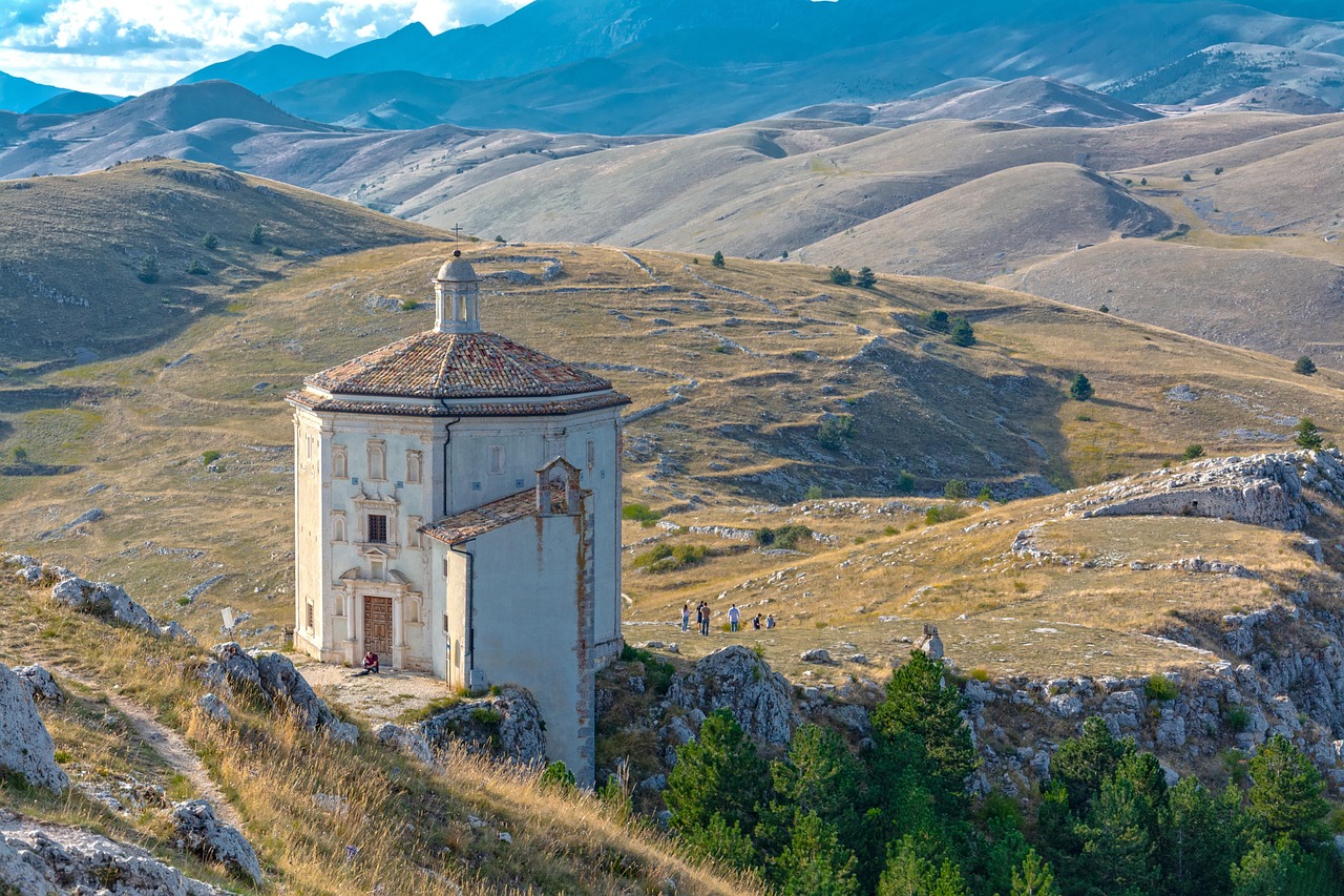 Panorama estivo dell'Abruzzo con colline verdi e cielo azzurro, ideale per vacanze lontane dalla folla.