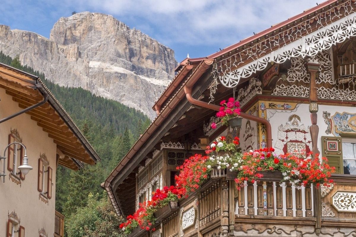 Borgo trentino con 100 case in legno in stile alpino, immerse nella natura montana.