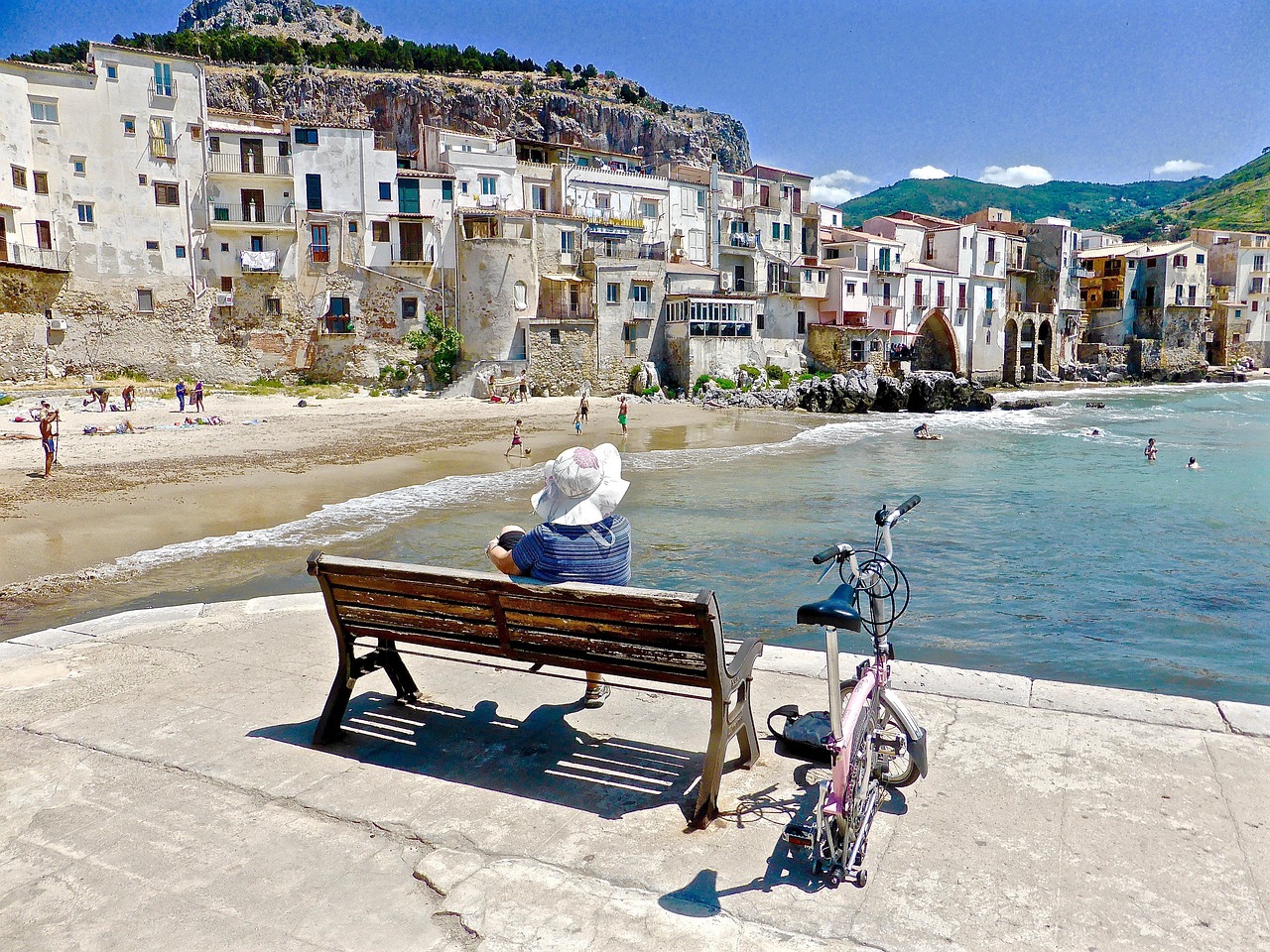 Isola italiana senza auto, con persone in bicicletta e a cavallo su sentieri naturali.